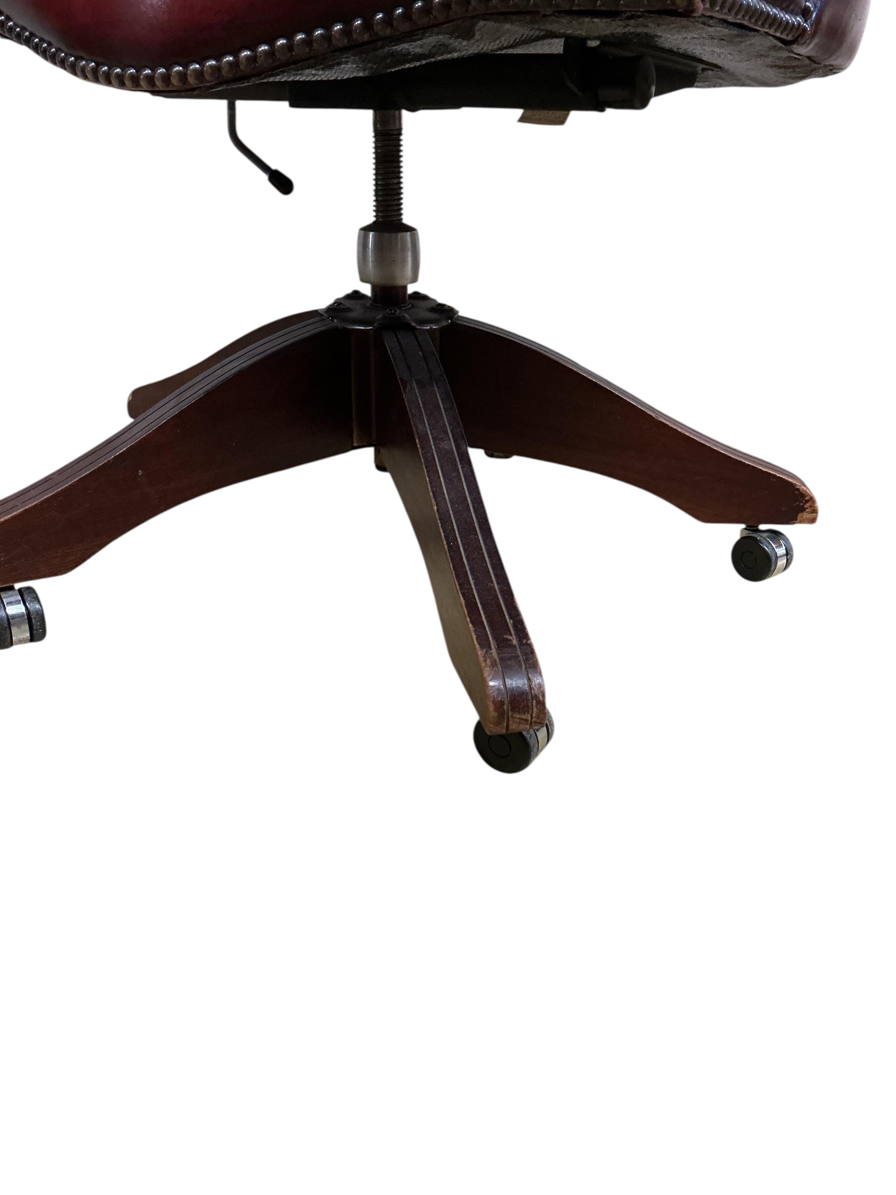 A reproduction buttoned burgundy leather swivel desk chair, width 62cm, depth 56cm, height 89cm